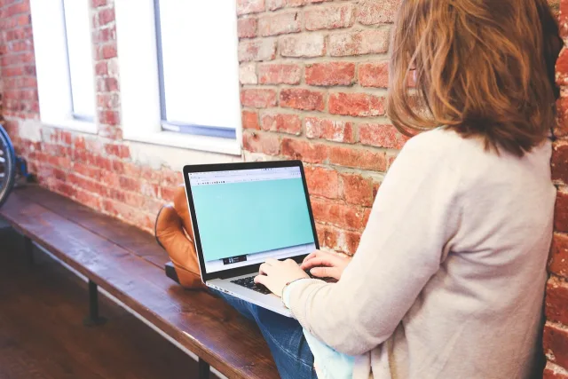 Pakistani student learning digital skills and AI content creation on a laptop