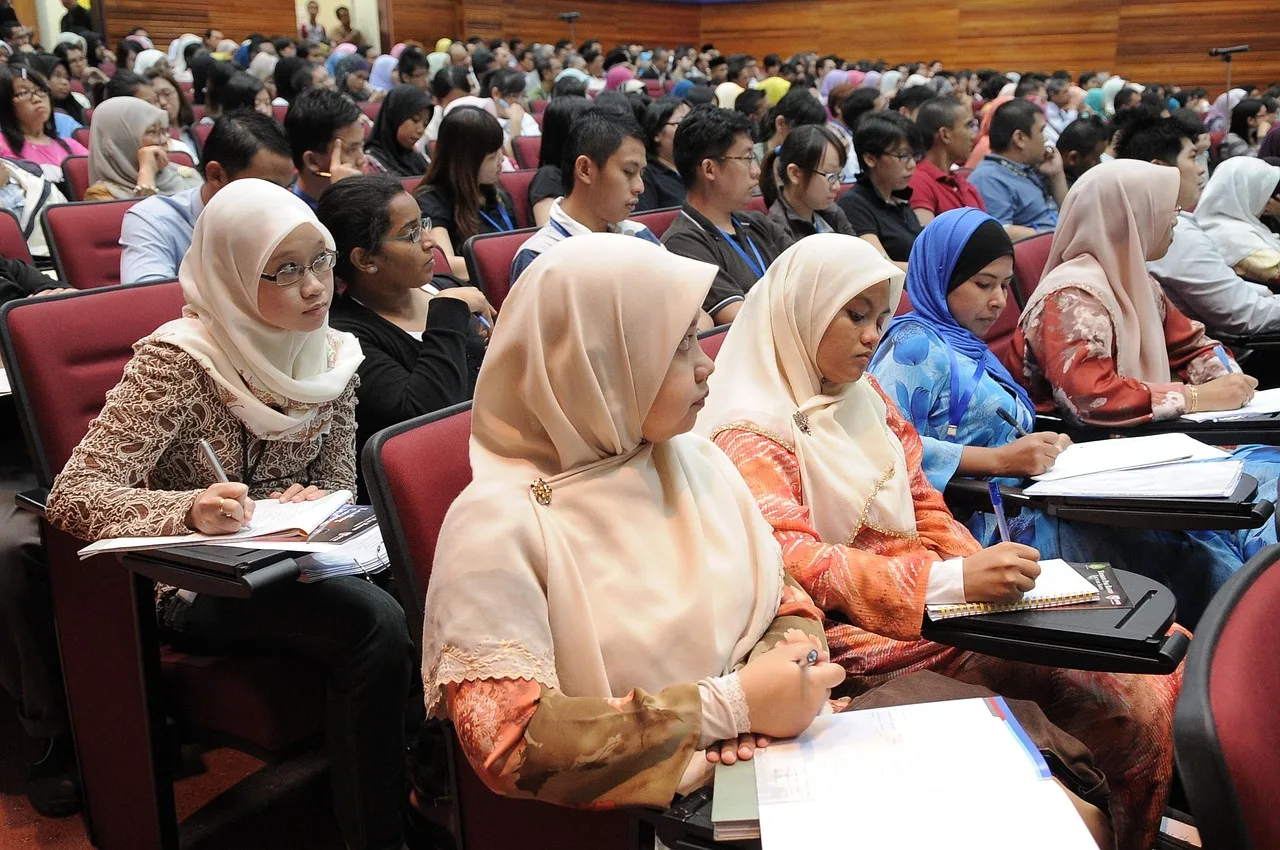 University students using laptops and digital tools in a modern classroom setting