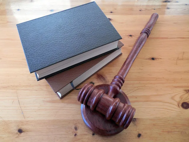 A stack of law books and a wooden gavel representing the Law Admission Test in Pakistan.