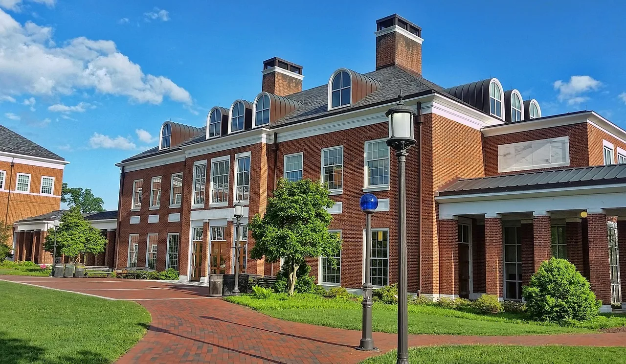 Students walking near a modern university campus building during daytime