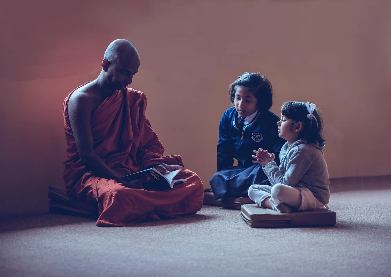 A teacher standing in a Pakistani classroom speaking to students.
